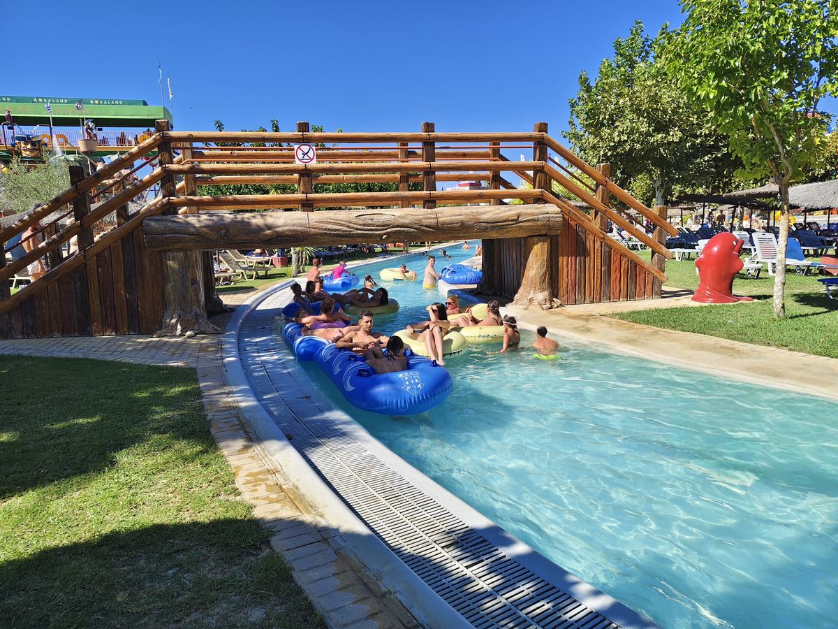 Winding lazy river pool with people floating on inner tubes