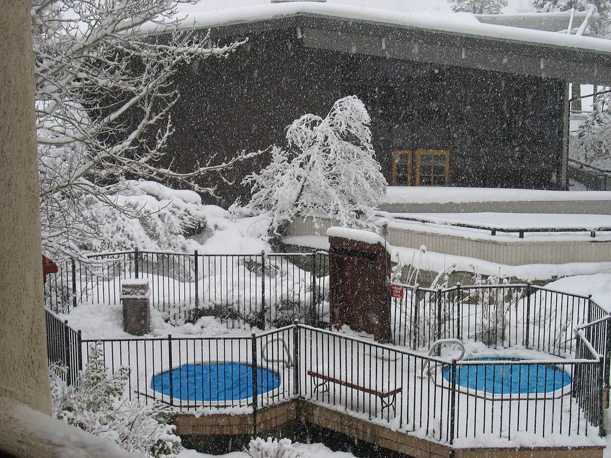 Outdoor hot tubs surrounded by deep snow during a winter storm