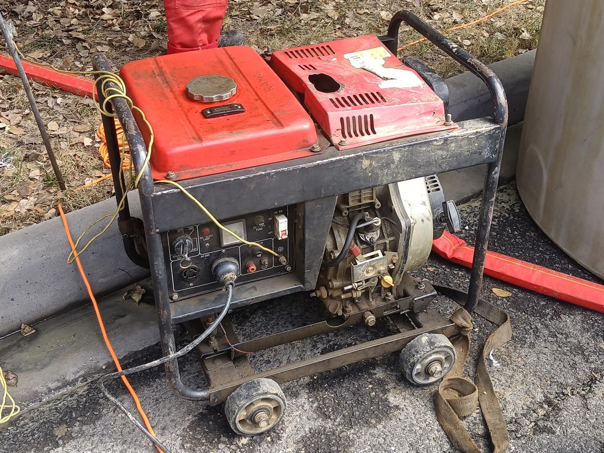 Portable gasoline generator on wheels parked on grass