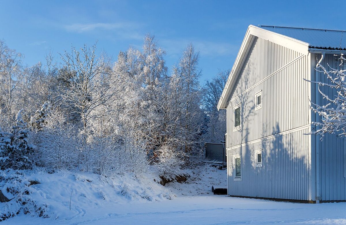 House in winter snow with storm clouds approaching