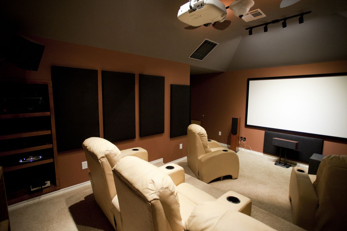 Dedicated home theater with recliners, acoustic wall panels and a projector screen
