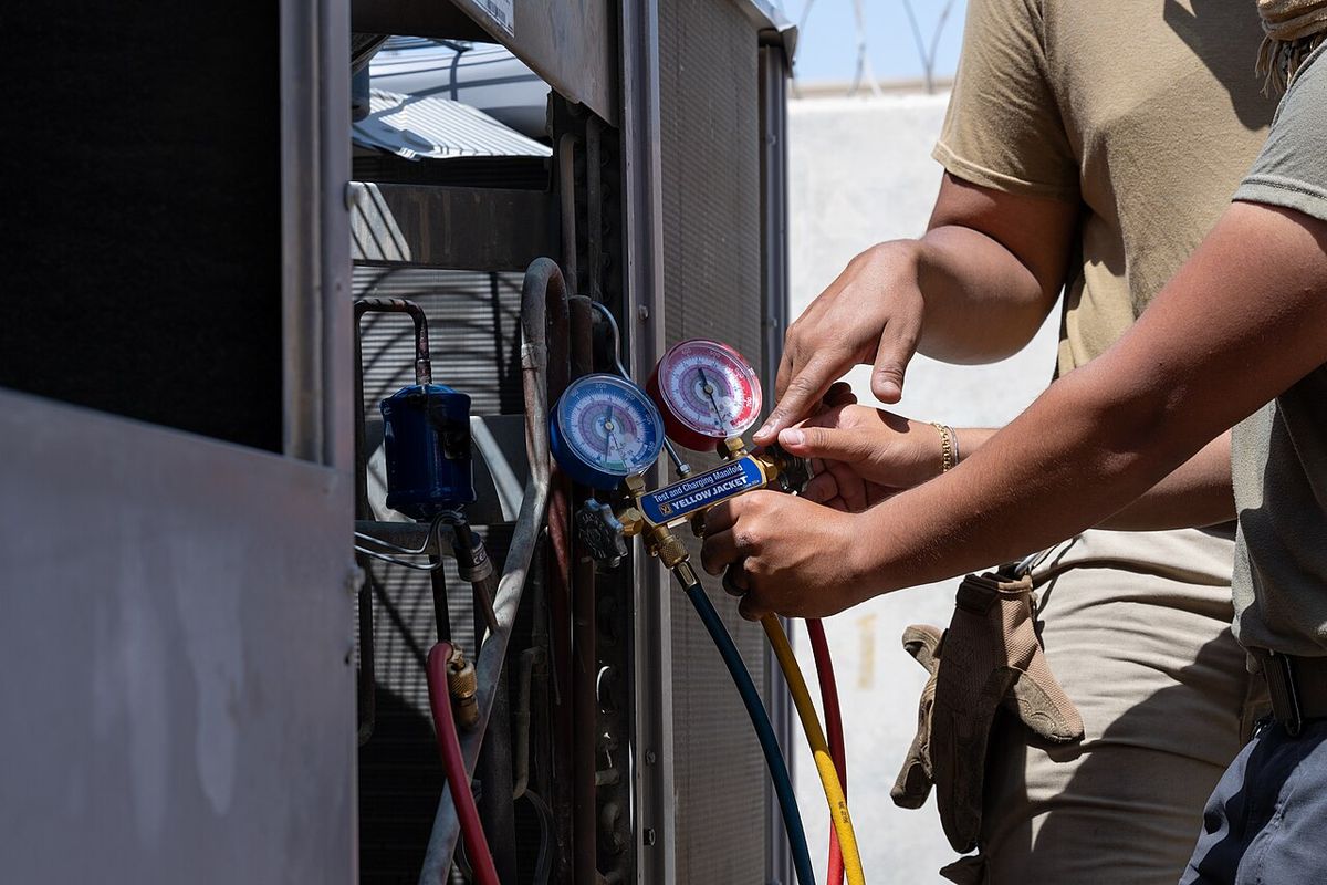 HVAC technician checking refrigerant gauges