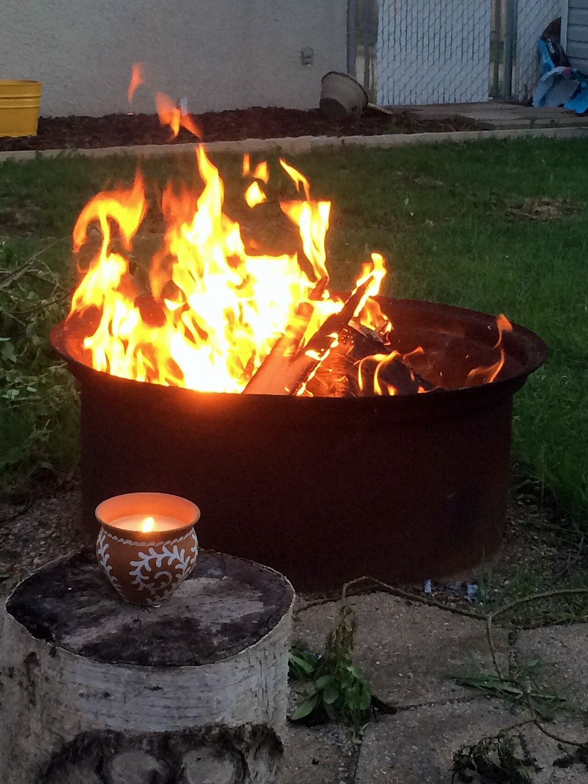 Backyard fire pit glowing in the evening