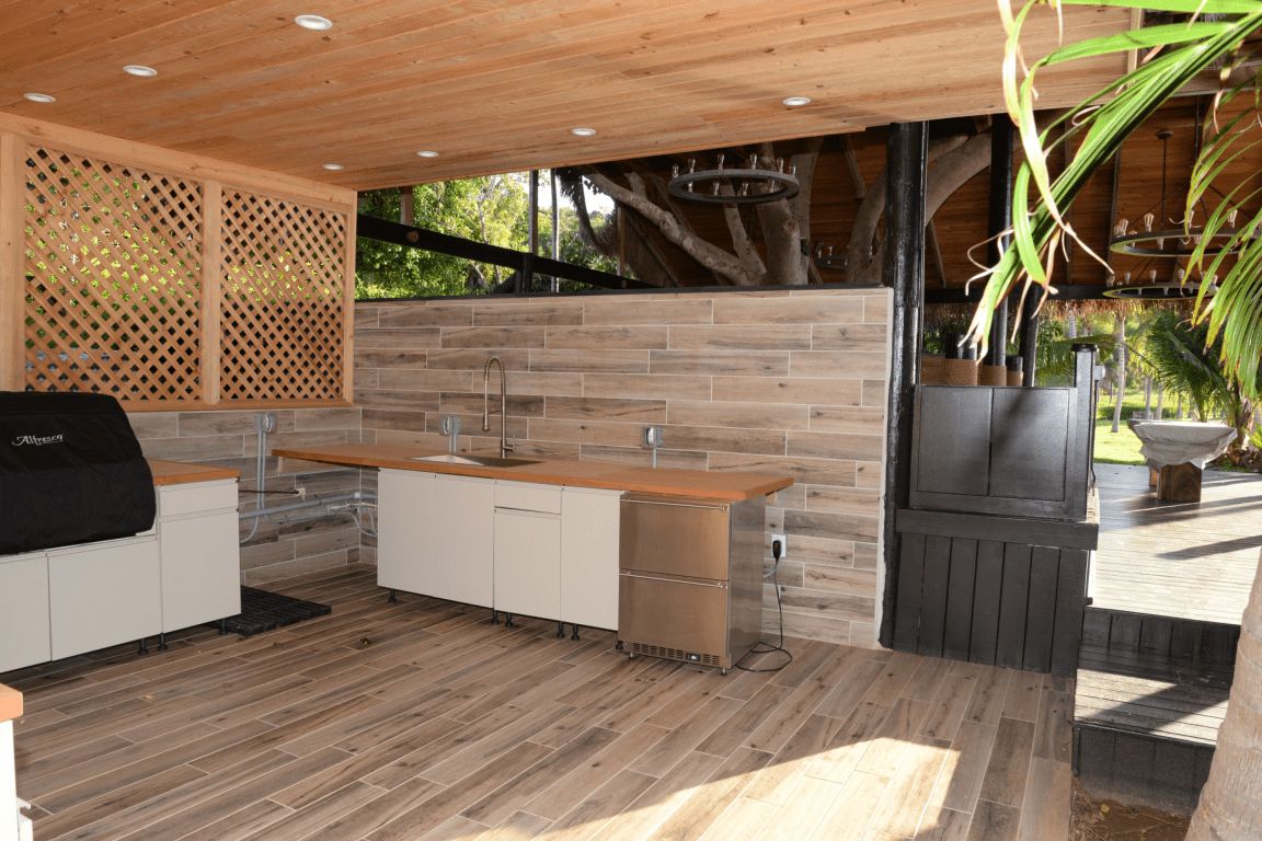 Covered outdoor kitchen with grill, sink and counter island