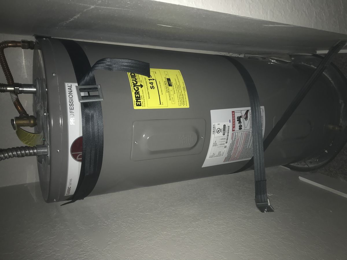 Electric water heater tank installed in a home utility space