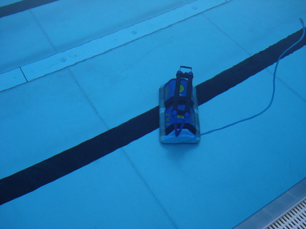 Robotic pool cleaner traveling along the floor of a swimming pool
